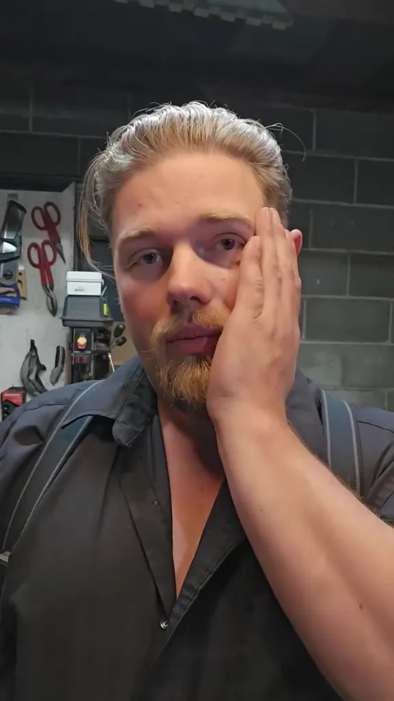 Noah Brown, an Alaskan Bush People star, holding his hand to his face.