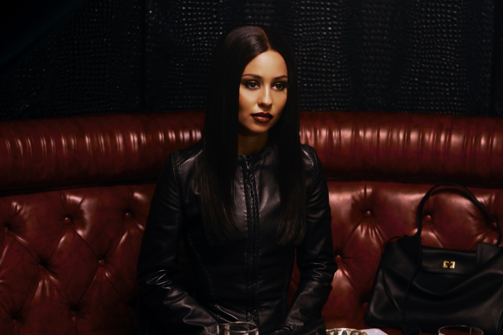 Alexa Demie as Maddy Perez from Euphoria Season 3 sitting on a red leather booth.