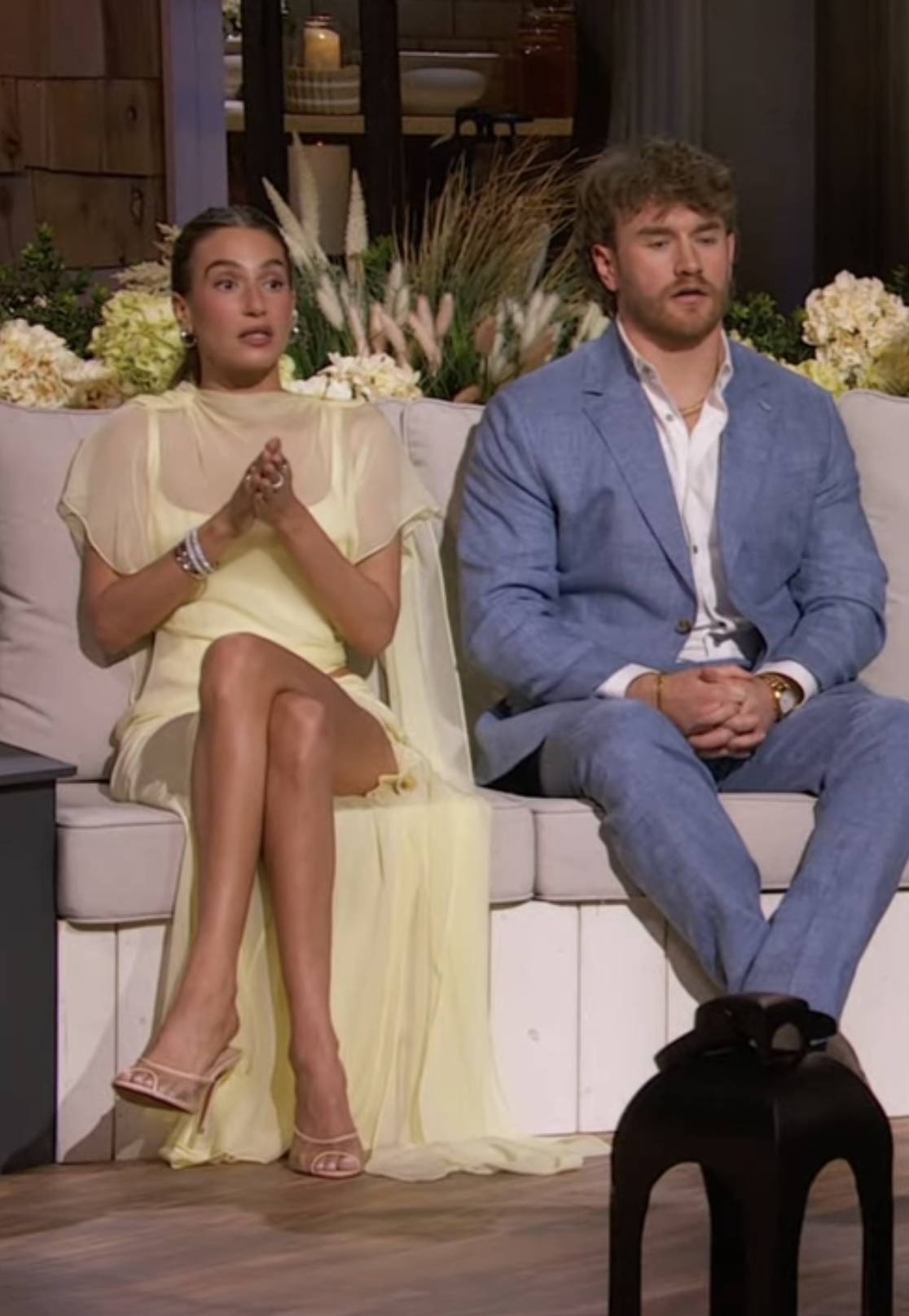 Amanda Batula and West Wilson sitting on a couch.