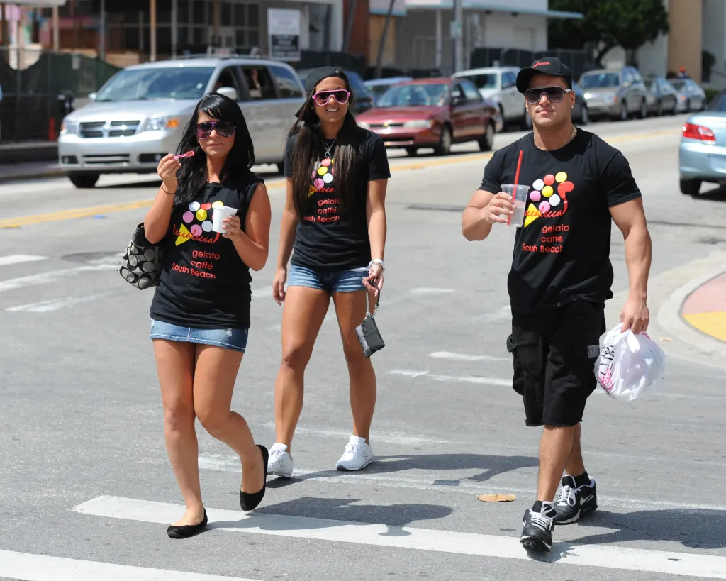 Angelina Pivarnick, Jenni Farley, and Ronnie Ortiz-Magro from Jersey Shore walk on a sunny Miami Beach street.