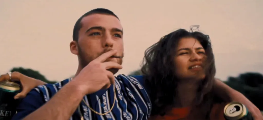 Angus Cloud with a cigarette and Zendaya with a drink.