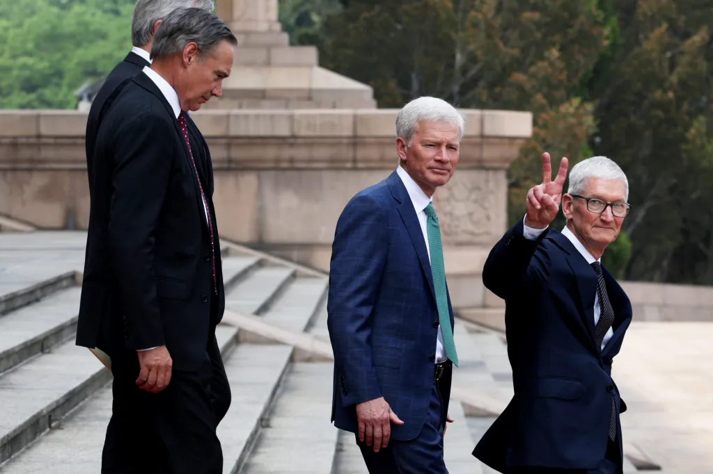 Apple CEO Tim Cook (R) gestures as he prepares to depart following a welcome ceremony at the Great Hall of the People on May 14, 2026 in Beijing, China.