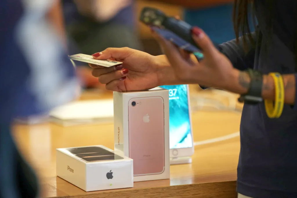 A customer uses a credit card to purchase a new iPhone 7 smartphone at an Apple Store.