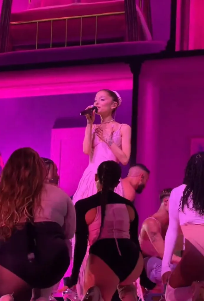 Ariana Grande performing on stage with dancers during her 