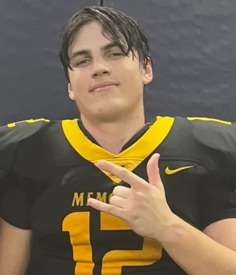 Austin Metcalf in a black and yellow football uniform making a 