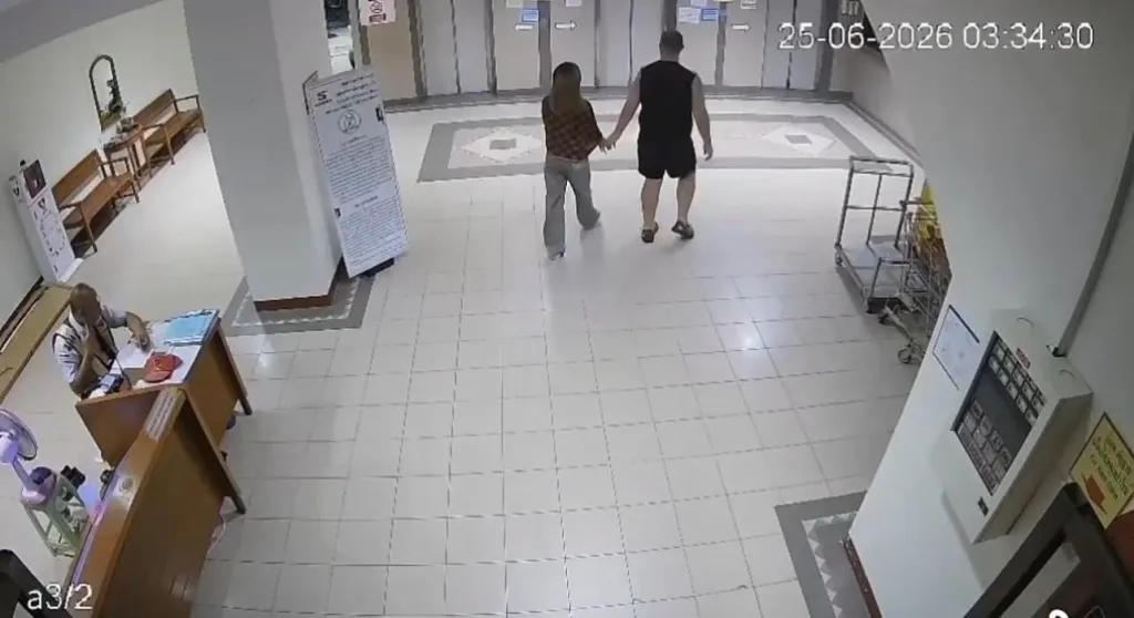 CCTV footage shows a couple walking hand-in-hand through a tiled lobby.