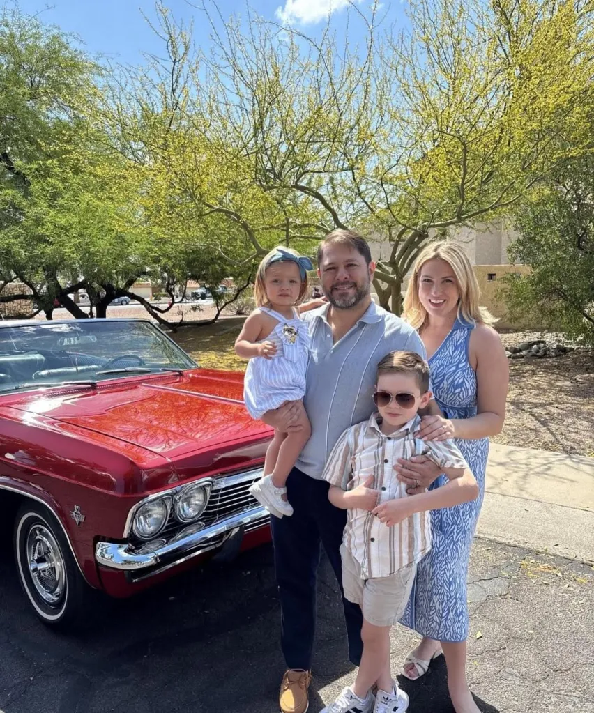 Senator Ruben Gallego with his wife, Sydney, and their two children, Isla and Cooper, standing in front of a red 1965 Chevy Impala.