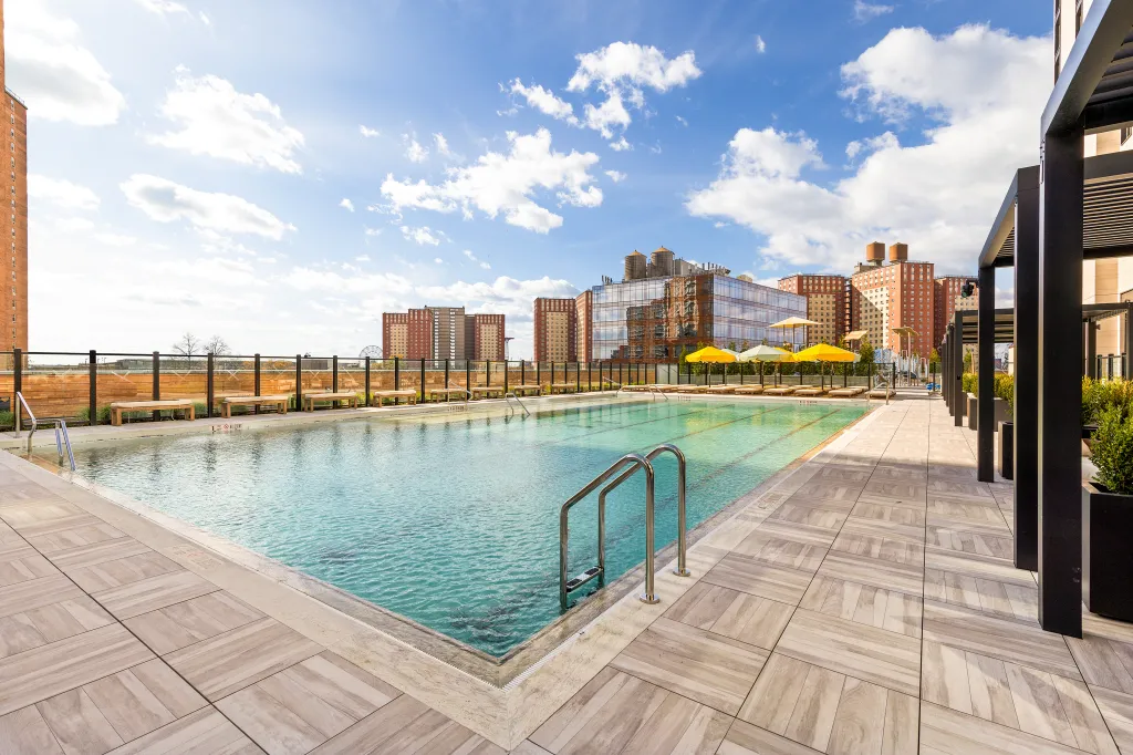 The pool is staffed by two full-time lifeguards and surrounded by a 100,000-square-foot amenity suite that includes a quarter-mile running track, hammam, sauna, pickleball courts, and a 24-hour concierge.