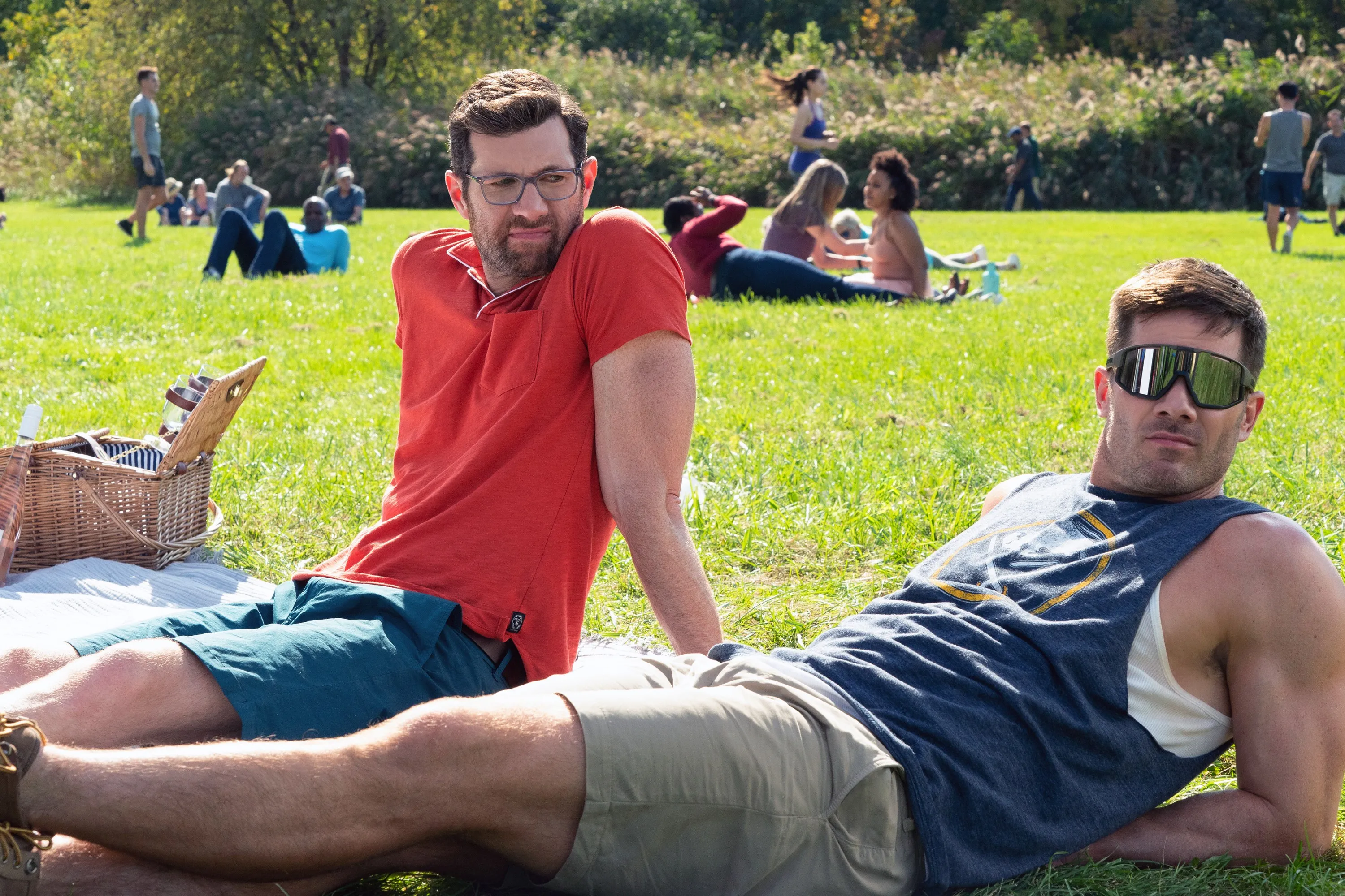 Billy Eichner and Luke Macfarlane picnicking on the grass in 
