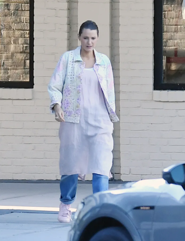 Blake Lively in a patterned jacket, pink dress, jeans, and pink trainers.