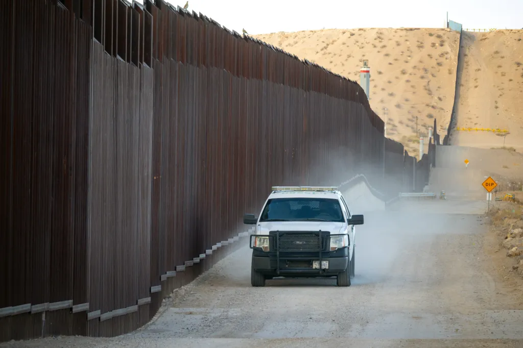 A white Border Patrol SUV drives along the U.S.-Mexico border wall in Sunland Park, NM.