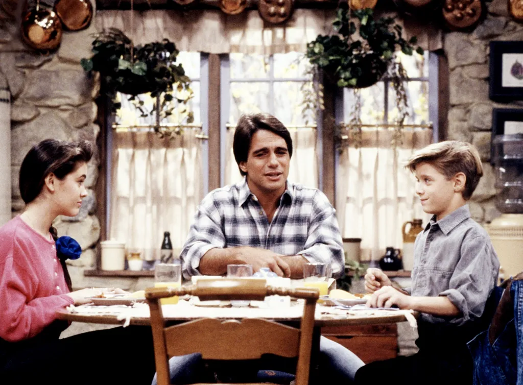 Alyssa Milano, Tony Danza, and Danny Pintauro sitting at a dinner table in 