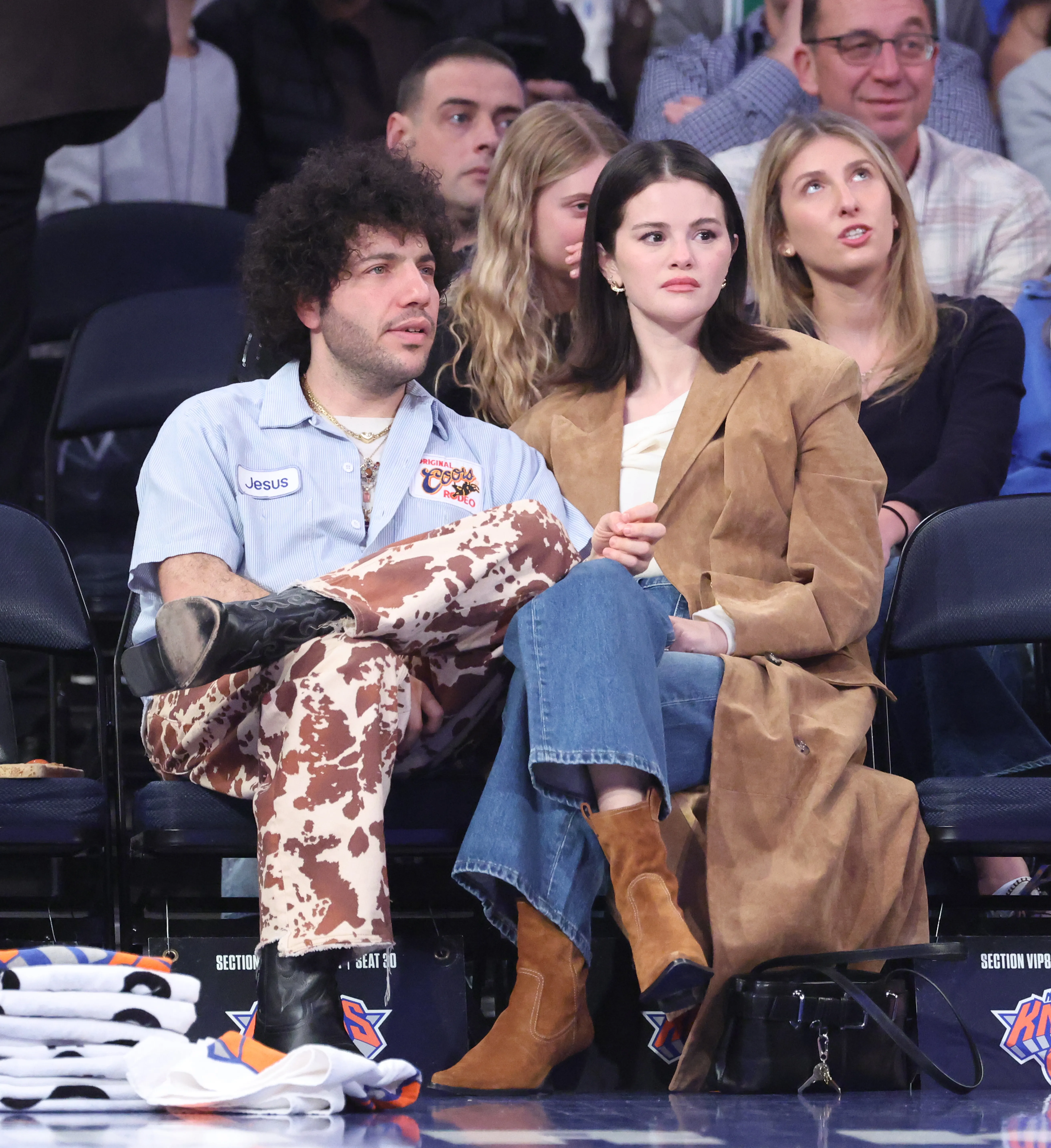 Selena Gomez and fiancé Producer Benny Blanco sit on celebrity row during the first quarter.
