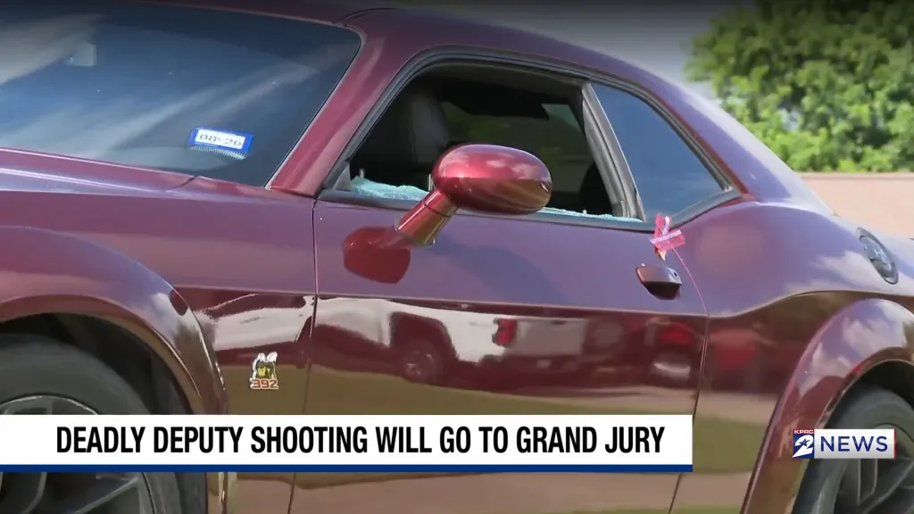 A maroon car with a broken window, indicating damage.
