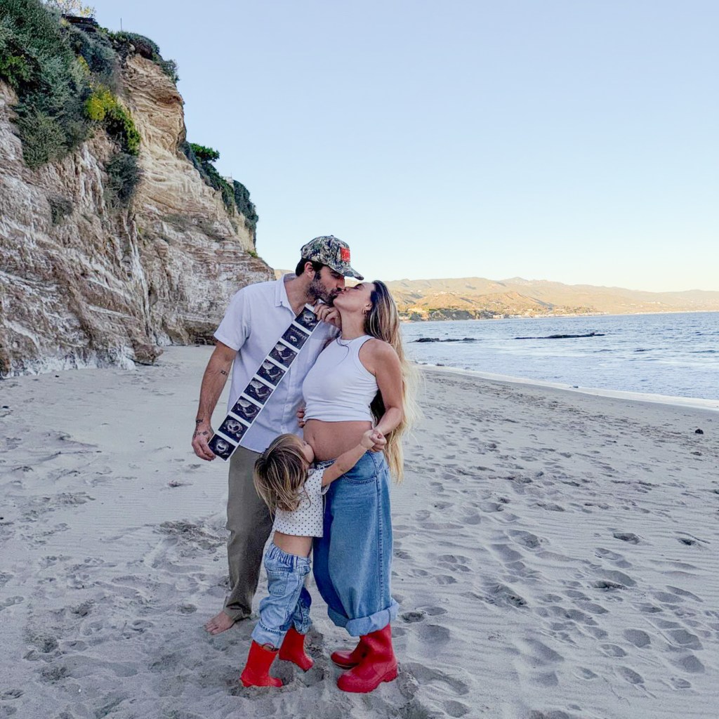 Brody Jenner and Tia Blanco kiss on a beach with their daughter, holding a strip of ultrasound images to announce their second pregnancy.
