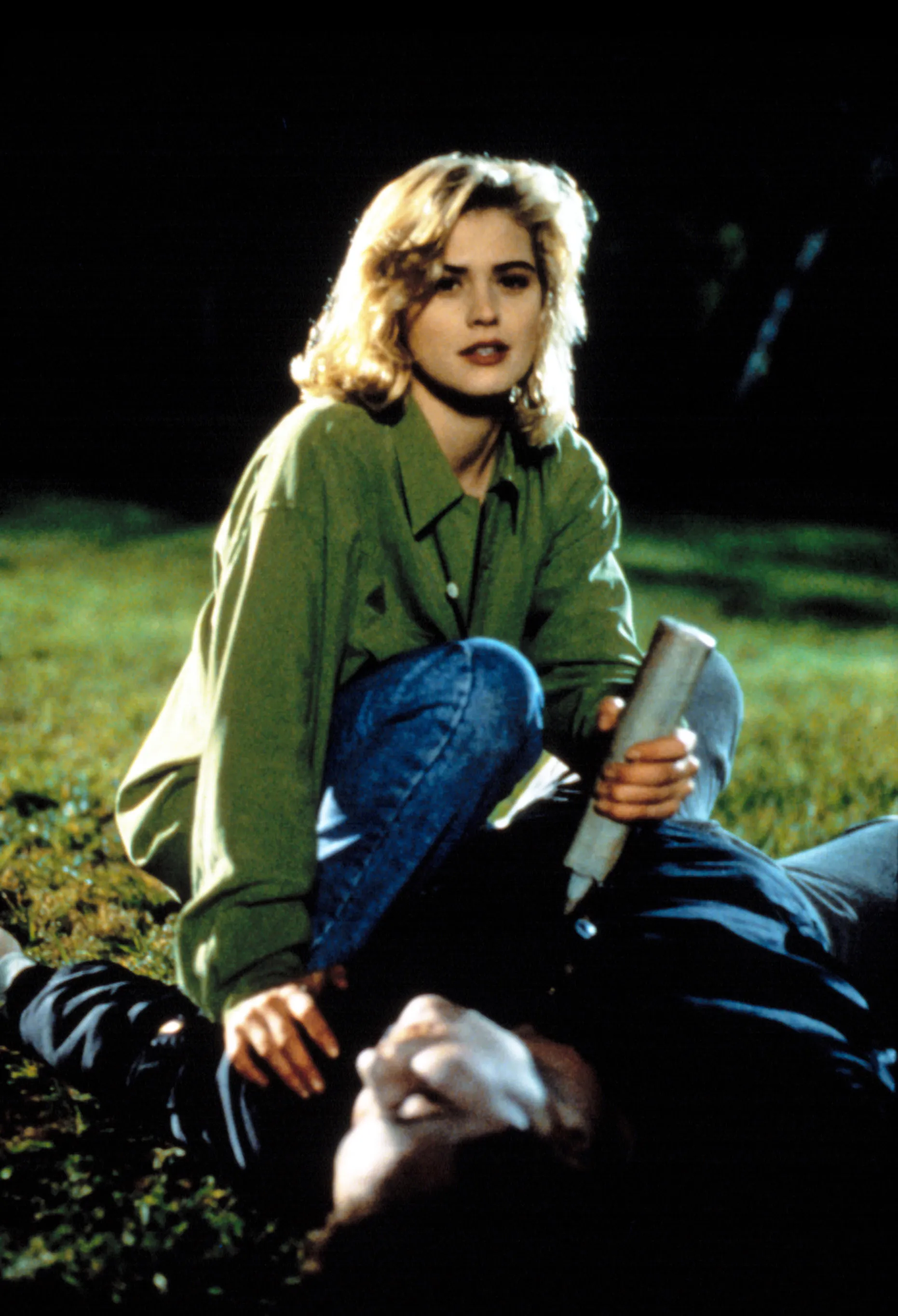 Kristy Swanson as Buffy Summers holding a stake over a person lying on the ground.