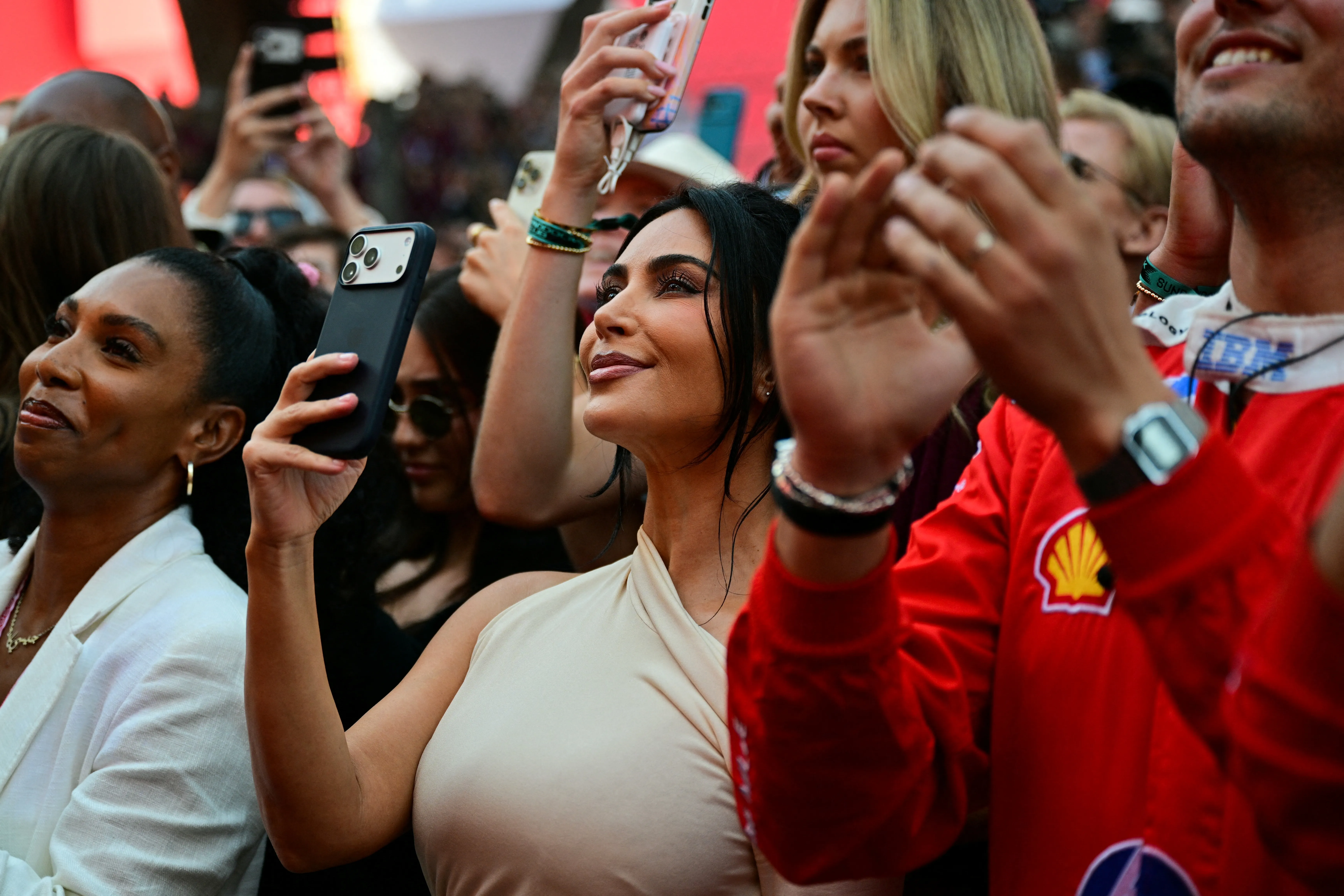 Kim Kardashian holds a cell phone up to capture the podium ceremony at the Monaco Formula 1 Grand Prix.
