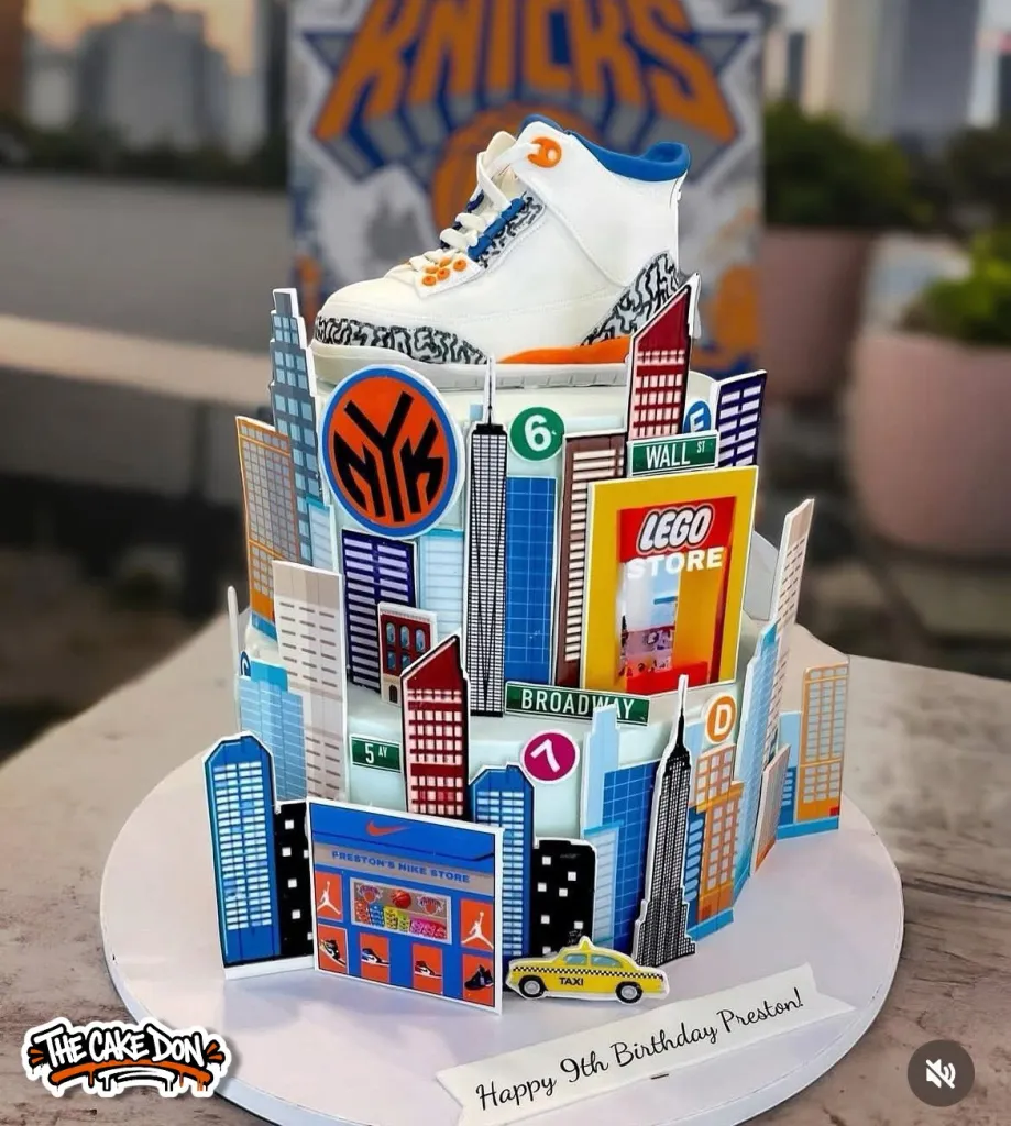 Specialty cake designed as a New York City skyline with a white sneaker on top and a 