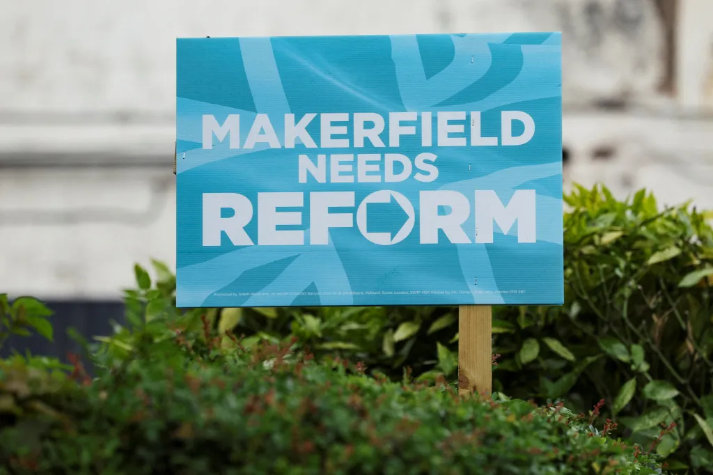 A Reform UK campaign placard in a garden reads 