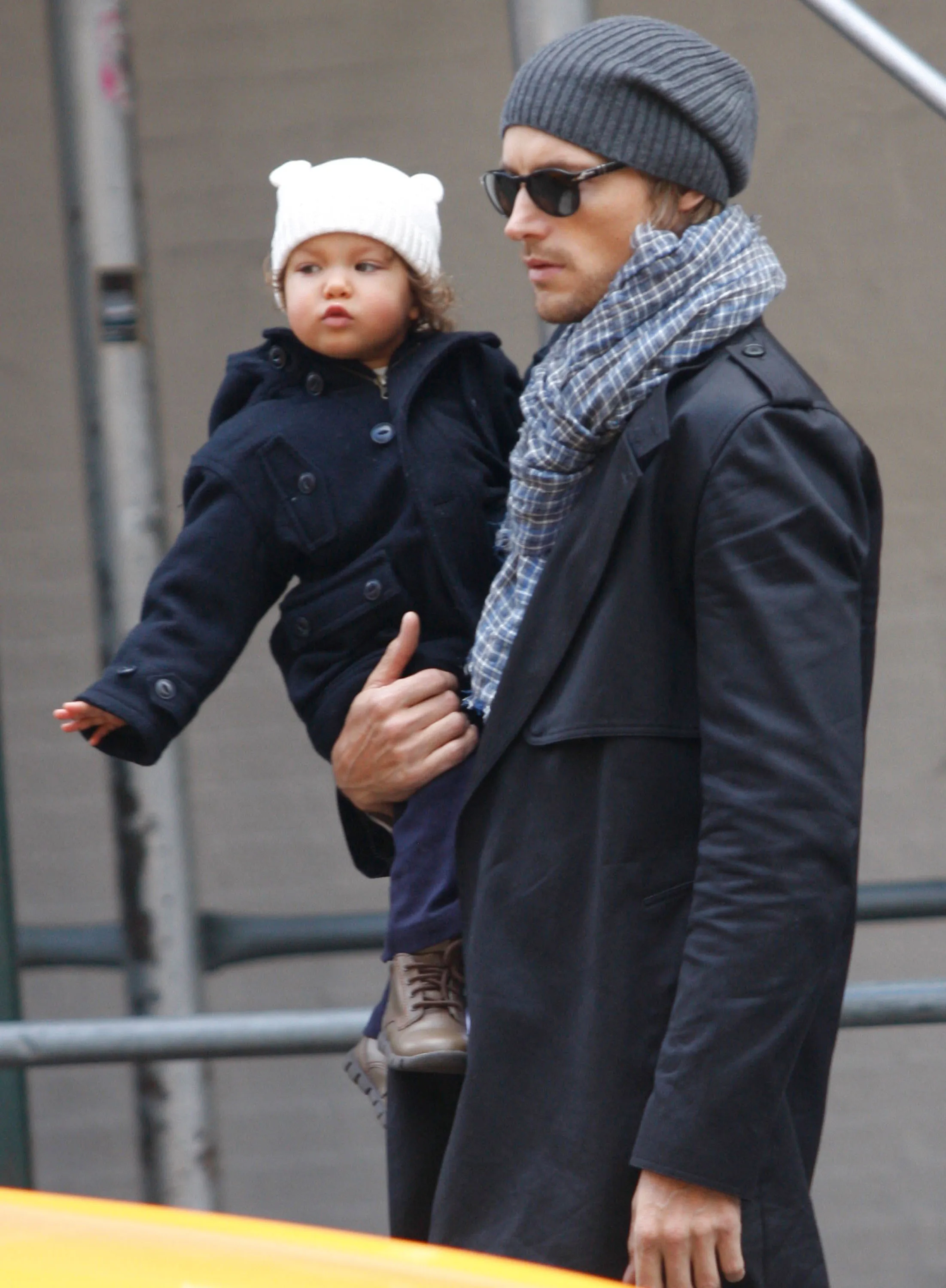Gabriel Aubry carrying his daughter Nahla Aubry, both dressed in winter coats and hats.