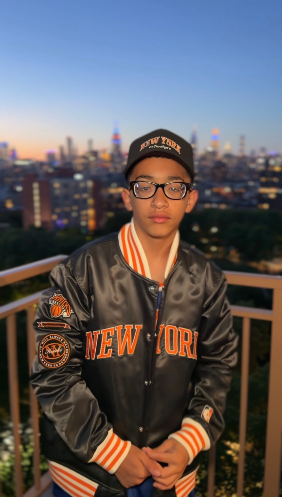 A boy wearing a Knicks jacket and 