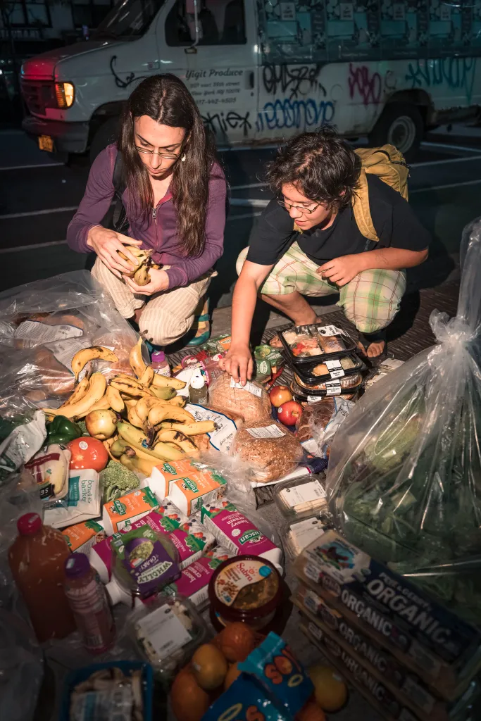 Young people rooting through garbage.