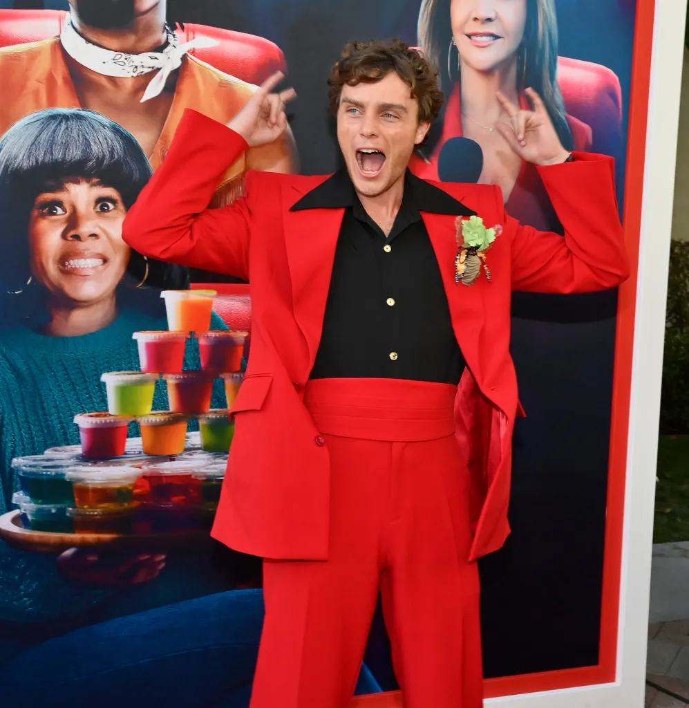 Cast member Cameron Scott Roberts poses in a red suit at the premiere of 