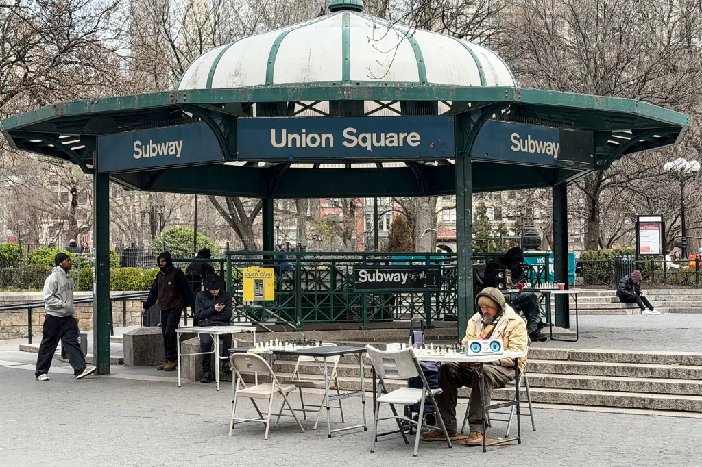 Chess players at tables under the Union Square subway entrance pavilion.