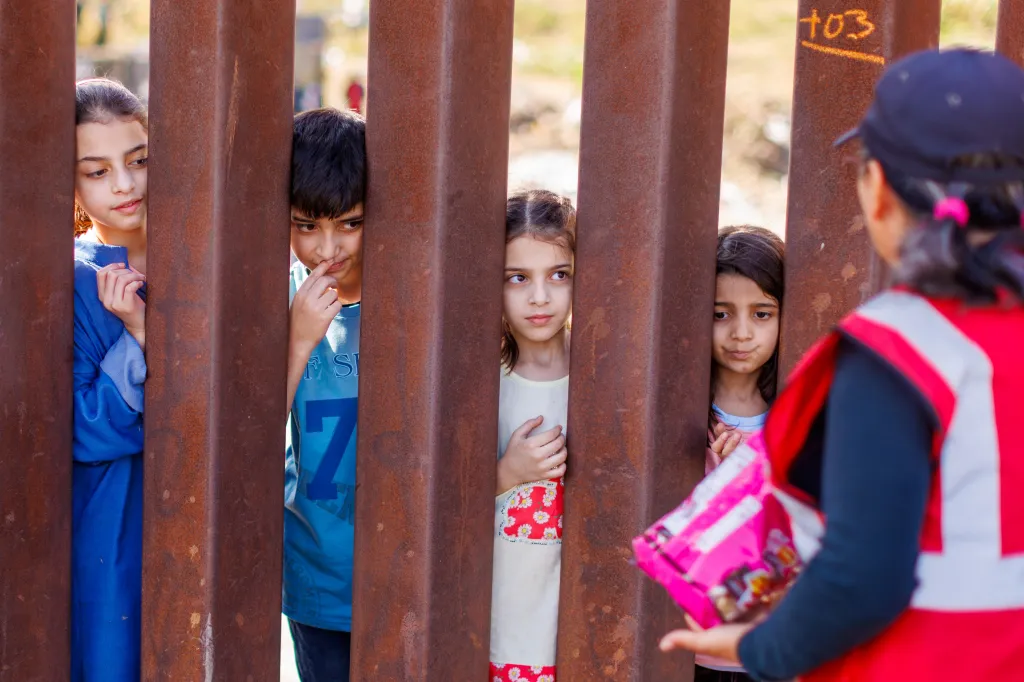 Children from Afghanistan receiving candy from a border worker in San Diego.