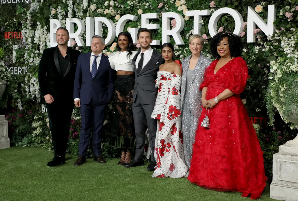 From left, Chris Van Dusen, Ted Sarandos, Simone Ashley, Jonathan Bailey, Charithra Chandran, Betsy Beers, and Shonda Rhimes pose at the Bridgerton Series 2 World Premiere.