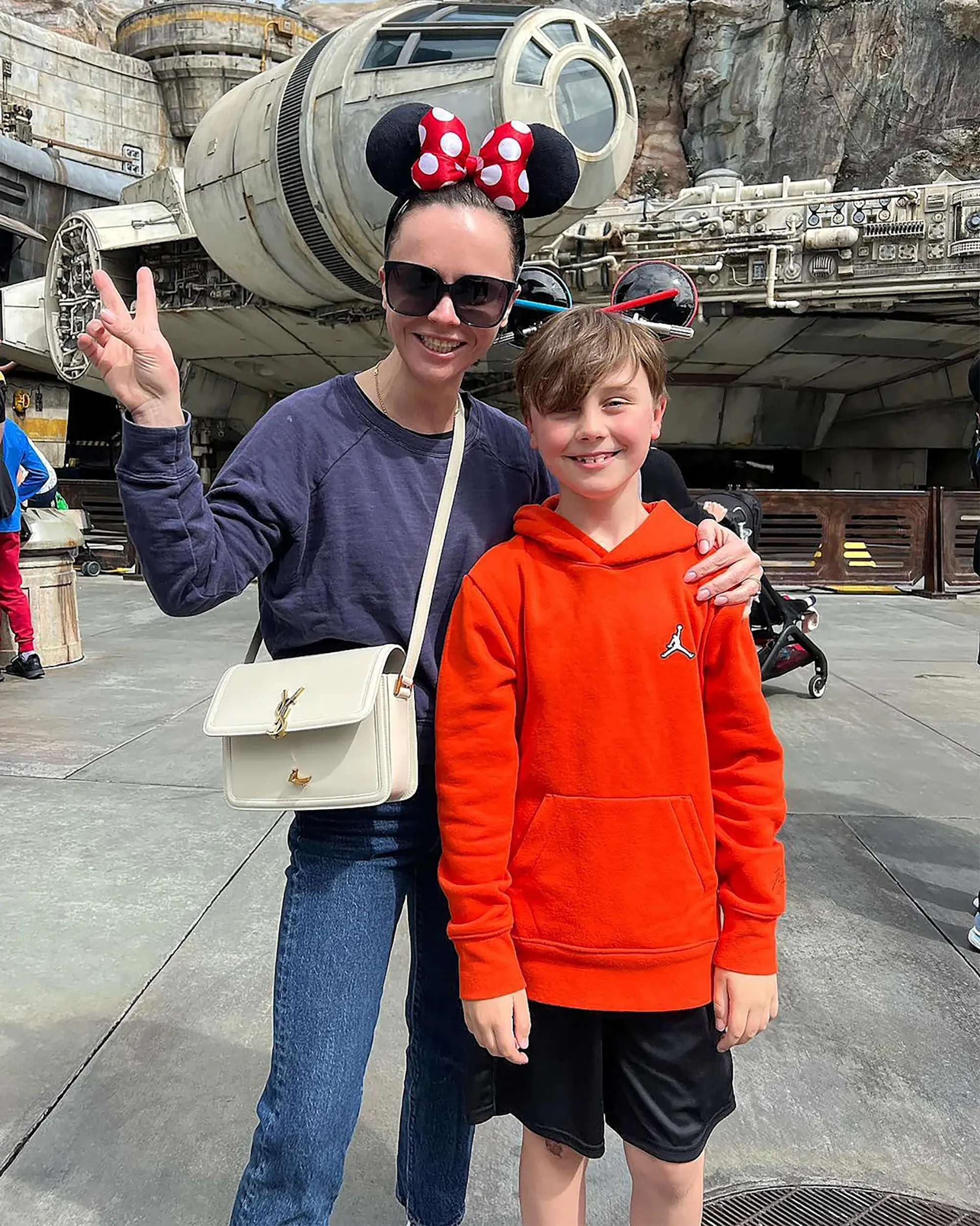 Christina Ricci with son Freddie at Disney World, posing in front of the Millennium Falcon.