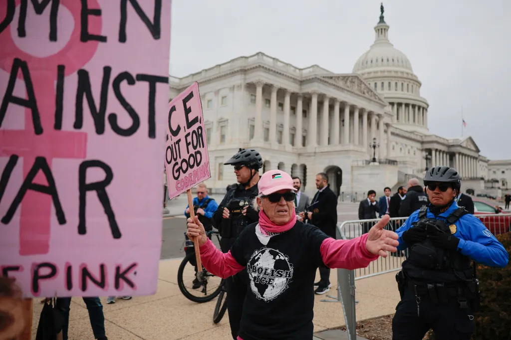 Code Pink activist Tighe Barry being told to leave a secure area by police with the U.S. Capitol in the background.