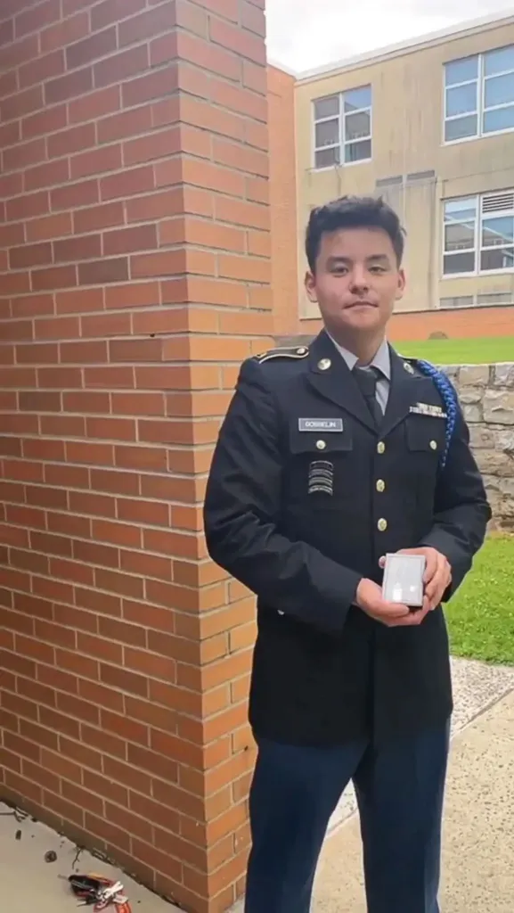 Collin Gosselin in a military uniform, holding a small white box.