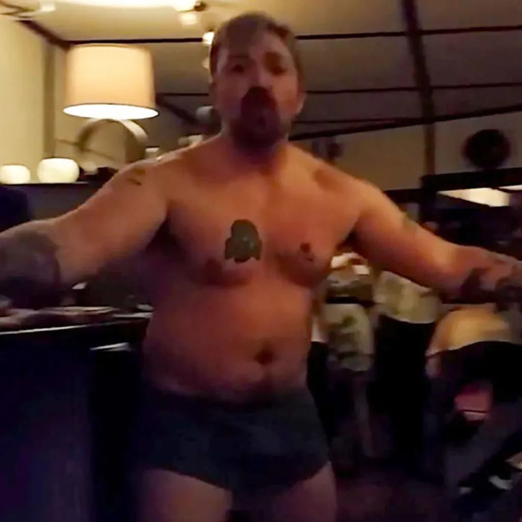 Graham Platner singing in briefs, revealing his chest tattoo at his brother's wedding.