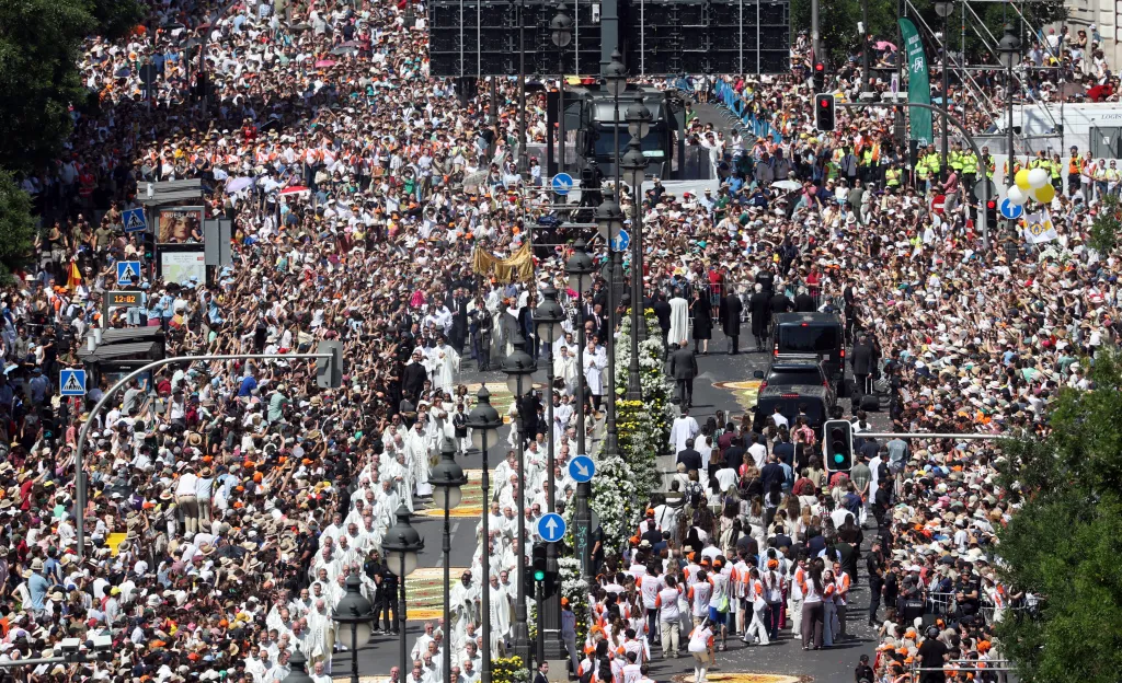 Pope Leo XIV walks under a processional canopy holding the monstrance containing the sacred host during the Corpus Christi procession in Madrid.