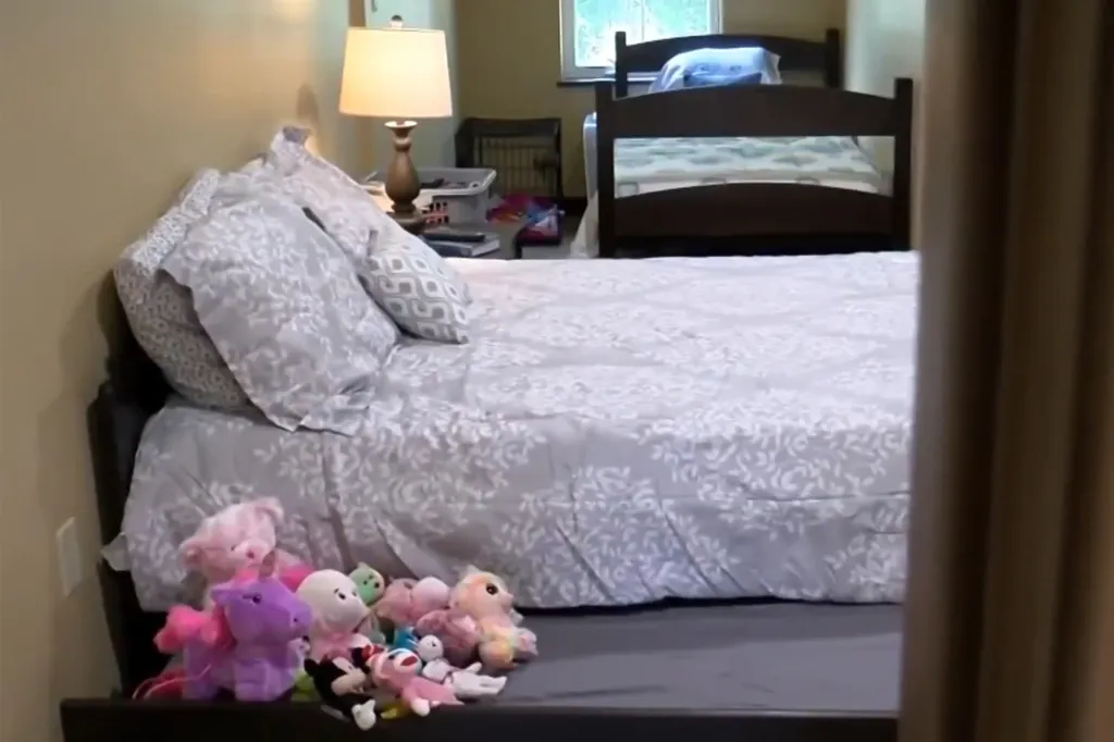 Two beds in a bedroom, with stuffed animals on the end of the bed in the foreground.