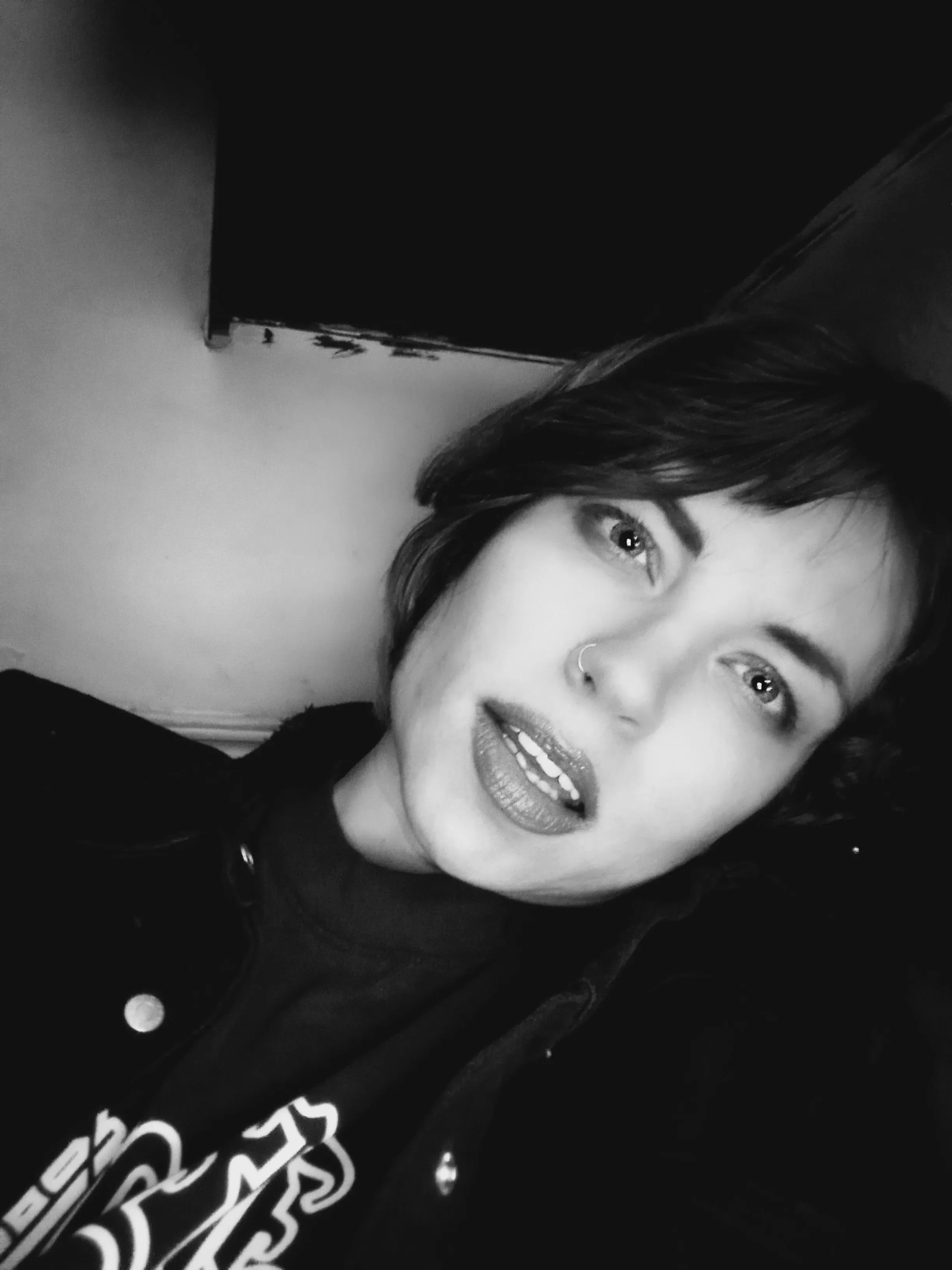 Daveigh Chase in a close-up, black and white portrait, with a nose ring and dark lipstick.