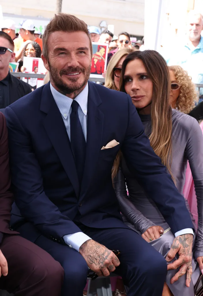 David and Victoria Beckham seated, David smiling at the camera.