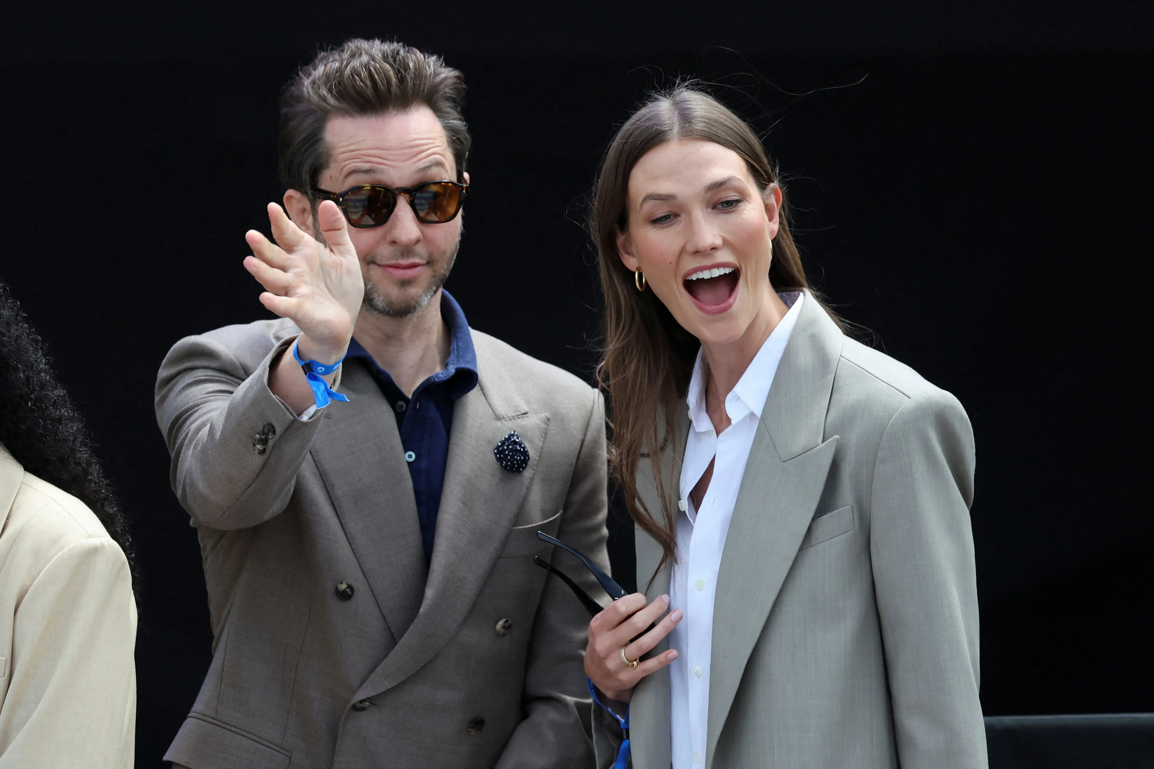 Derek Blasberg waves while Karlie Kloss grins at the Obama Presidential Center dedication ceremony.