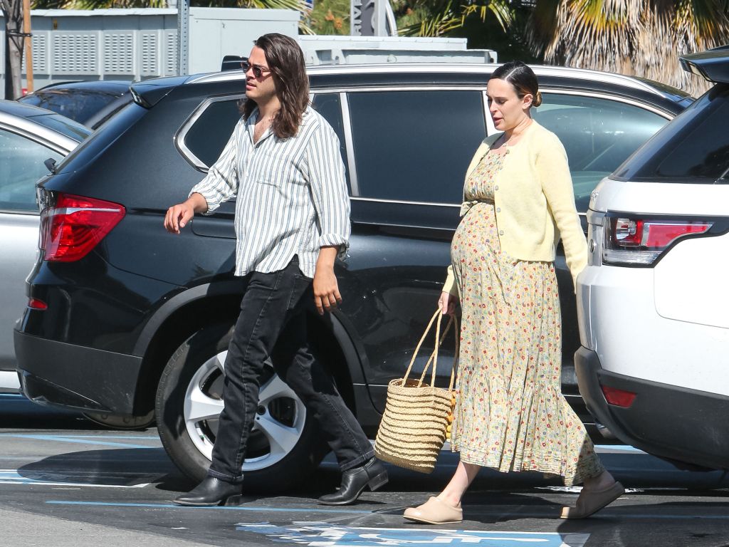 Derek Richard Thomas and Rumer Willis, who is visibly pregnant, walk through a parking lot.