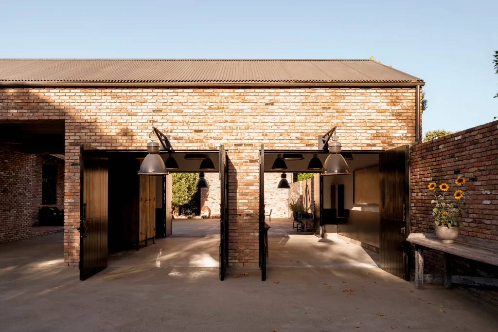 Exterior view of the Diane Keaton home with an expansive brick wall and a corrugated metal roof.