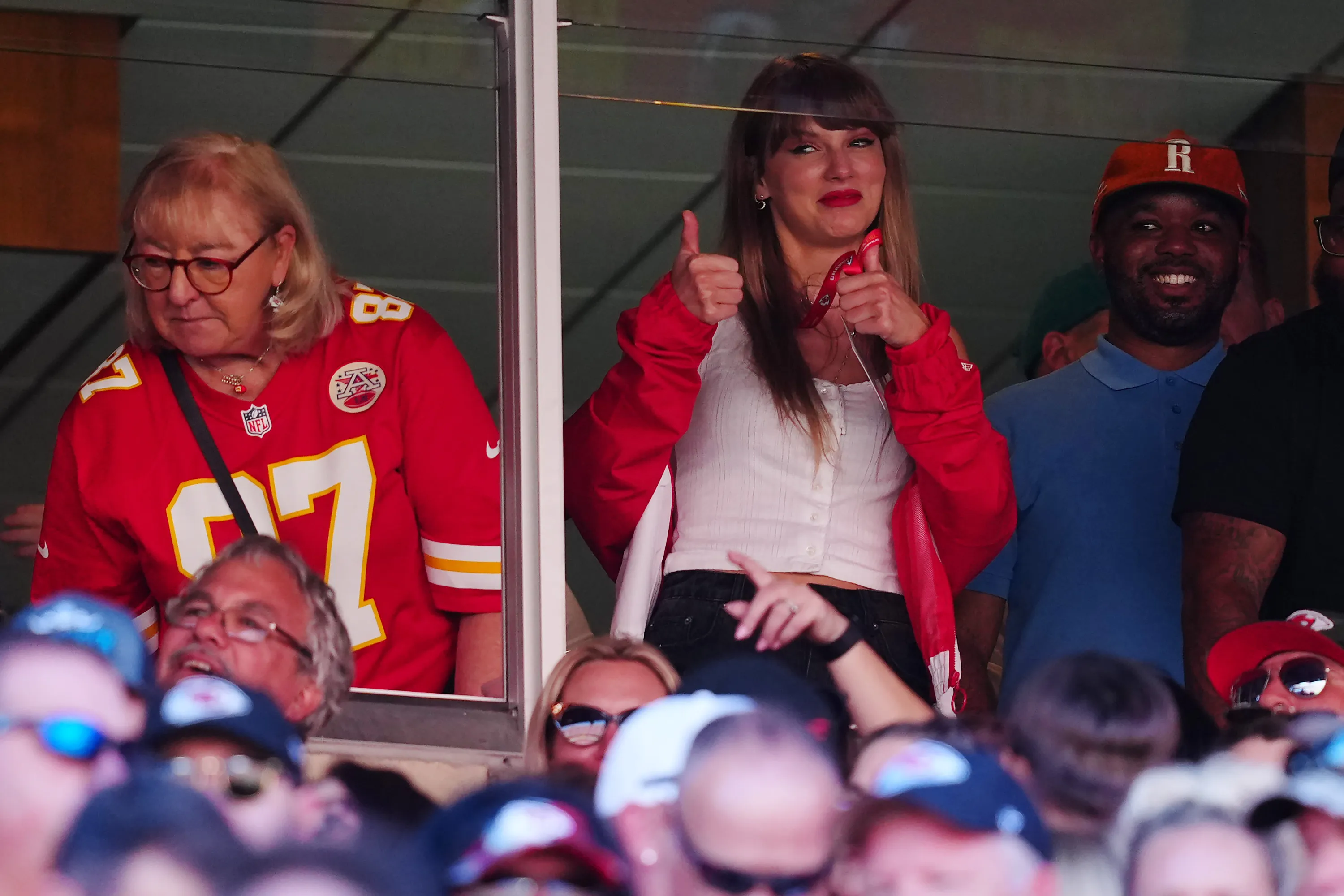 Taylor Swift and Donna Kelce cheering at a football game.