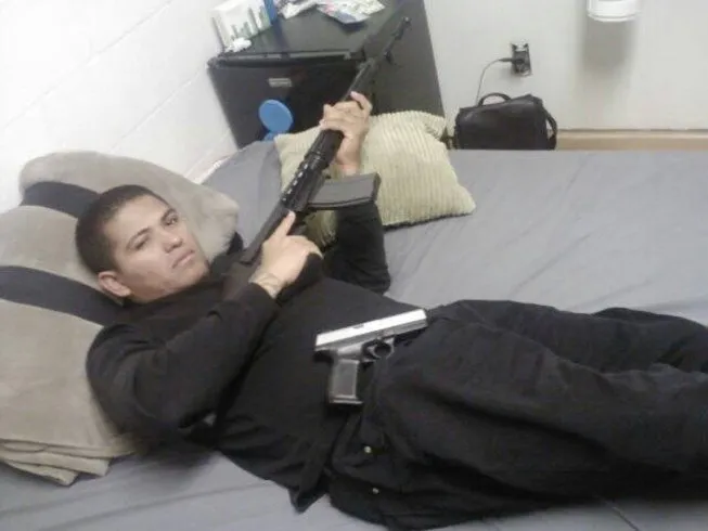 Edgard Velasquez, 43, of Reseda, holding a rifle and with a handgun on his lap.
