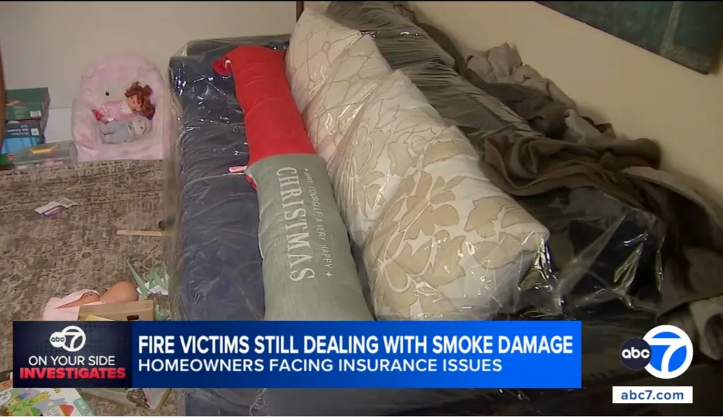 Furniture and belongings, including a Christmas pillow, wrapped in plastic due to smoke damage, with an overlay text 
