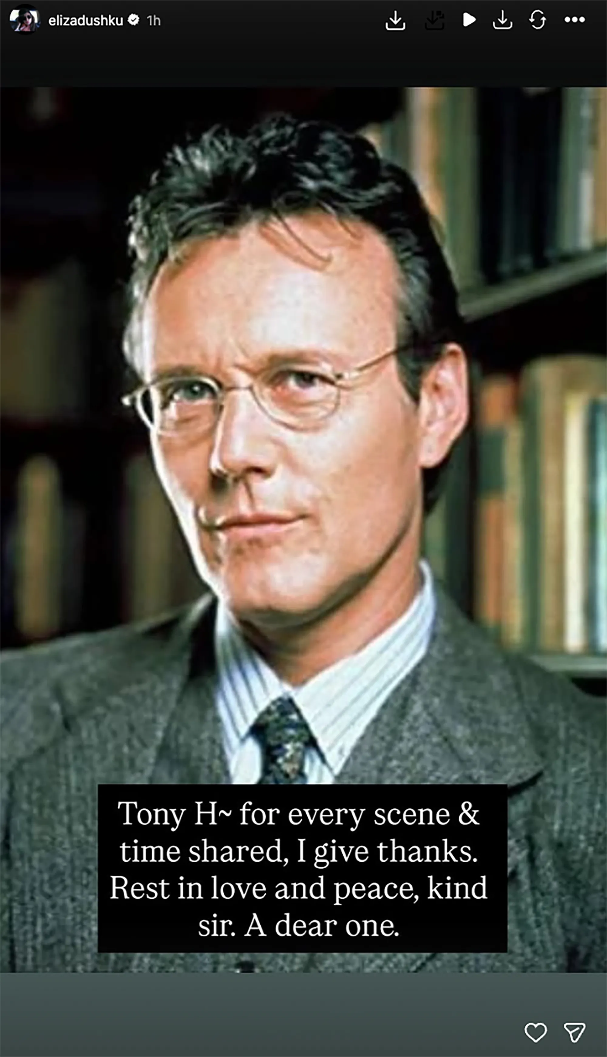 Anthony Head, wearing a suit and glasses, with a tribute message from Eliza Dushku.
