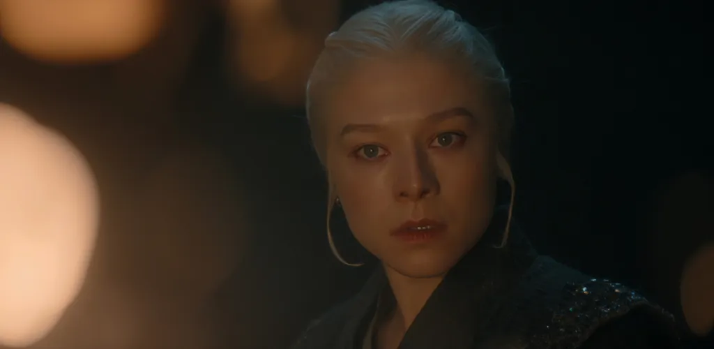Emma D'Arcy as Rhaenyra Targaryen in House of the Dragon, looking serious with pale hair and red-rimmed eyes.
