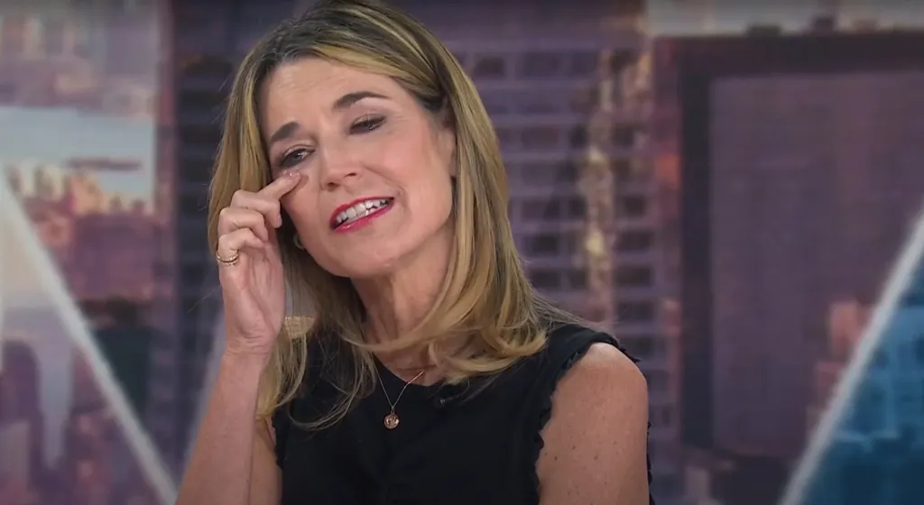 Savannah Guthrie tearing up and wiping a tear from her eye.