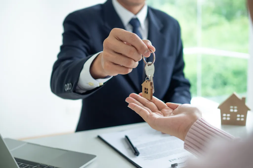 A real estate agent giving house keys to a client.