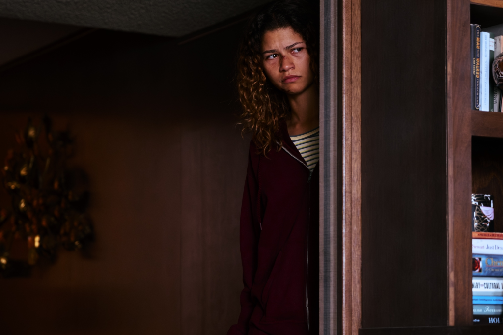 Zendaya as Rue from Euphoria peering out from behind a door.