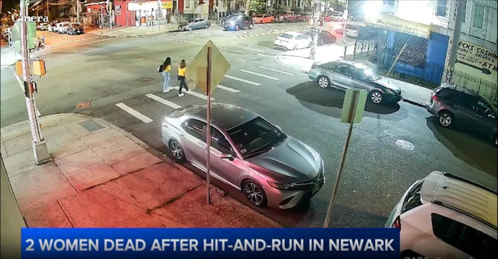 Two women cross an intersection in Newark, NJ, moments before they were struck by a car on June 20, 2026.